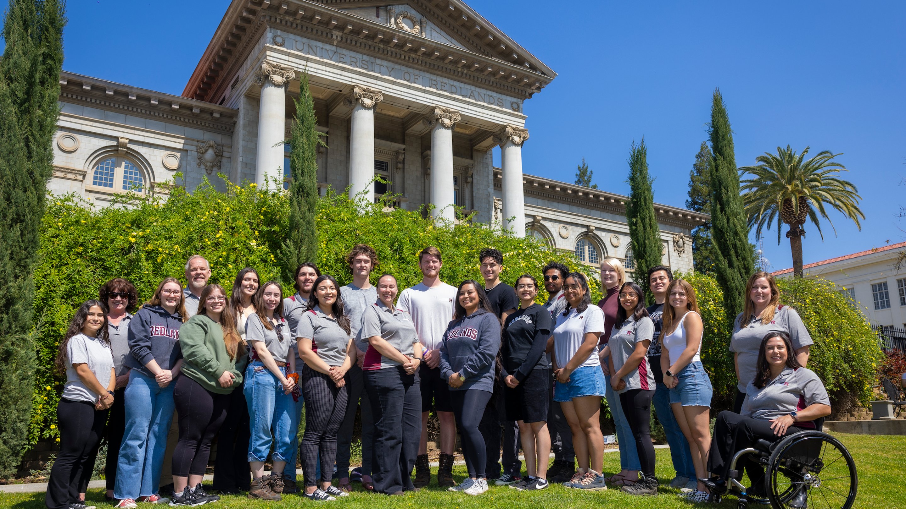 a group of people posing for a photo in front of a building