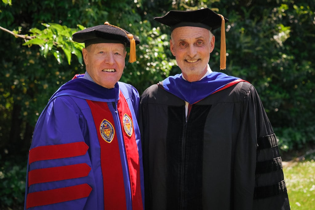 two men in graduation gowns and caps