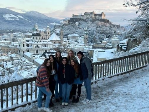 a group of people posing for a picture in front of a snowy city