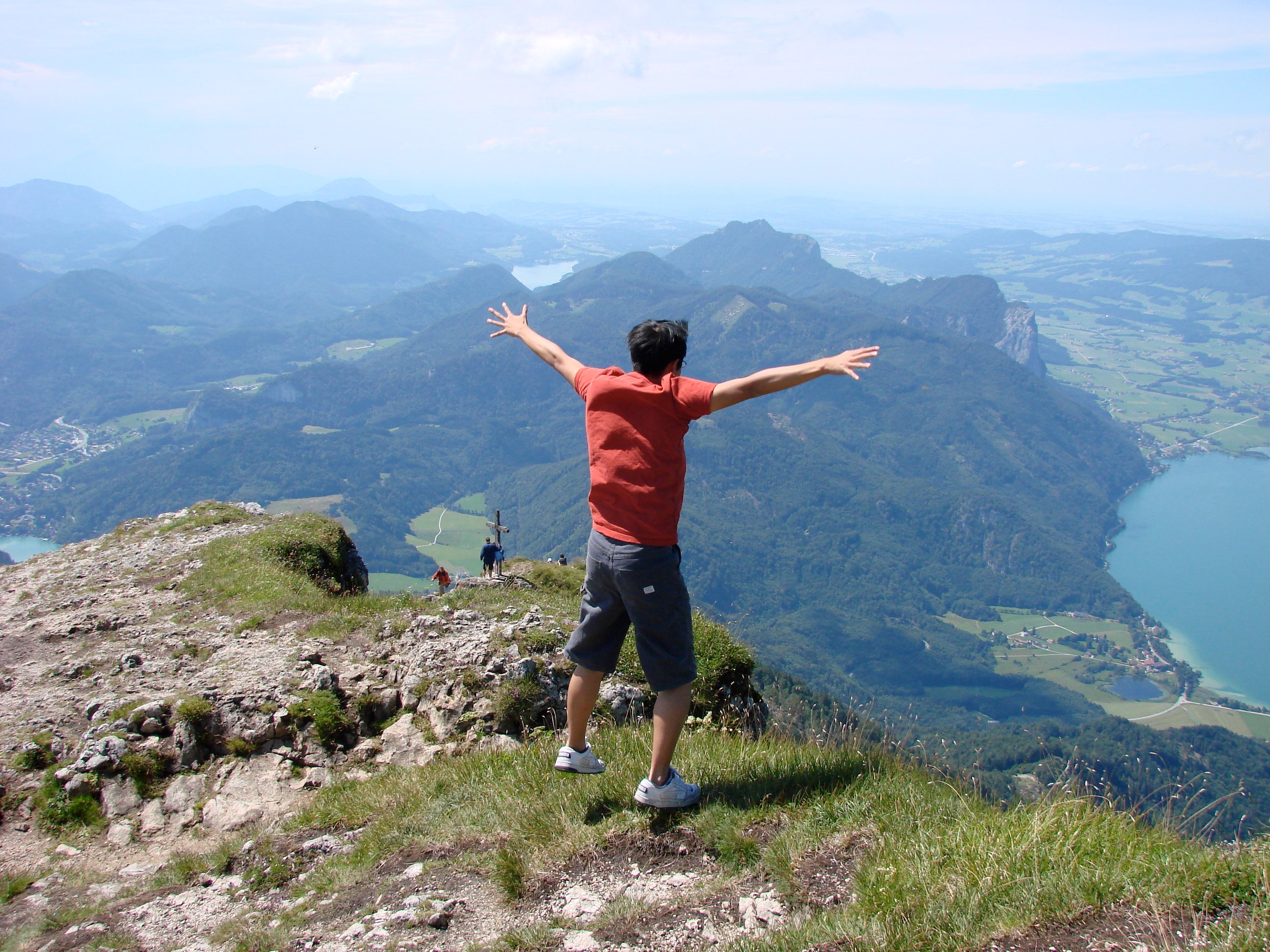 a man standing on a mountain with his arms outstretched