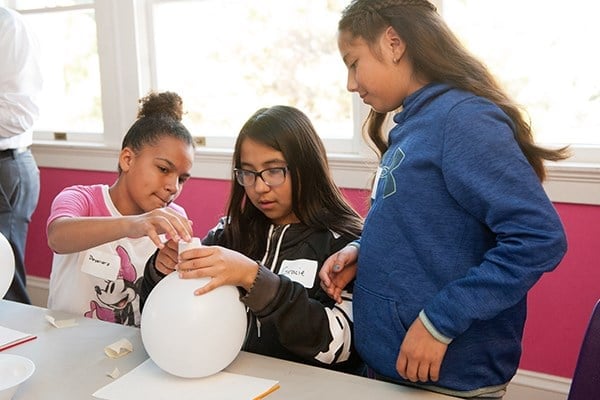 a group of girls working on a balloon