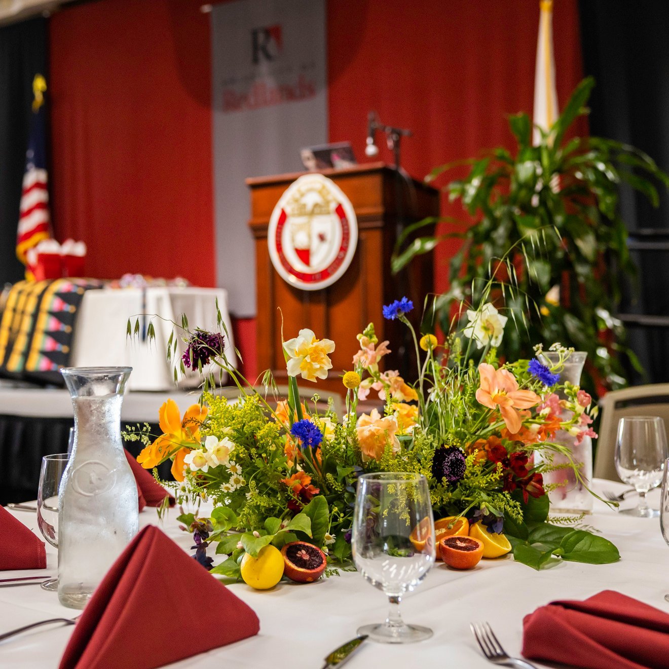 a table set with flowers and glasses on it