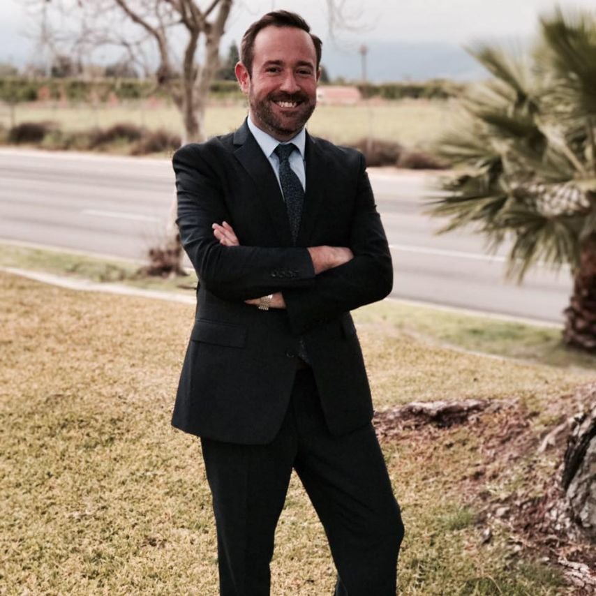 a man in a suit standing with his arms crossed