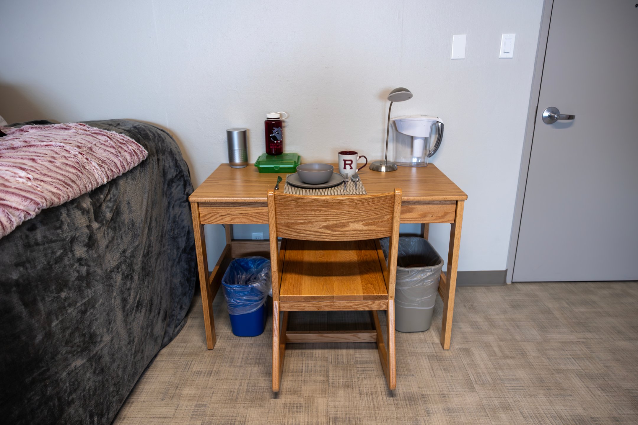 a table with a chair and a table with a lamp and a cup on it