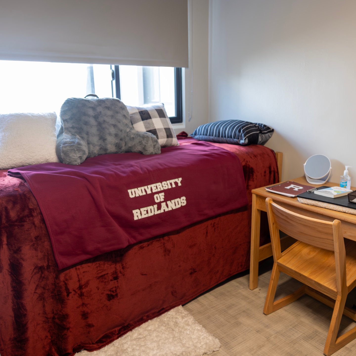 a bed with pillows and a desk in a room