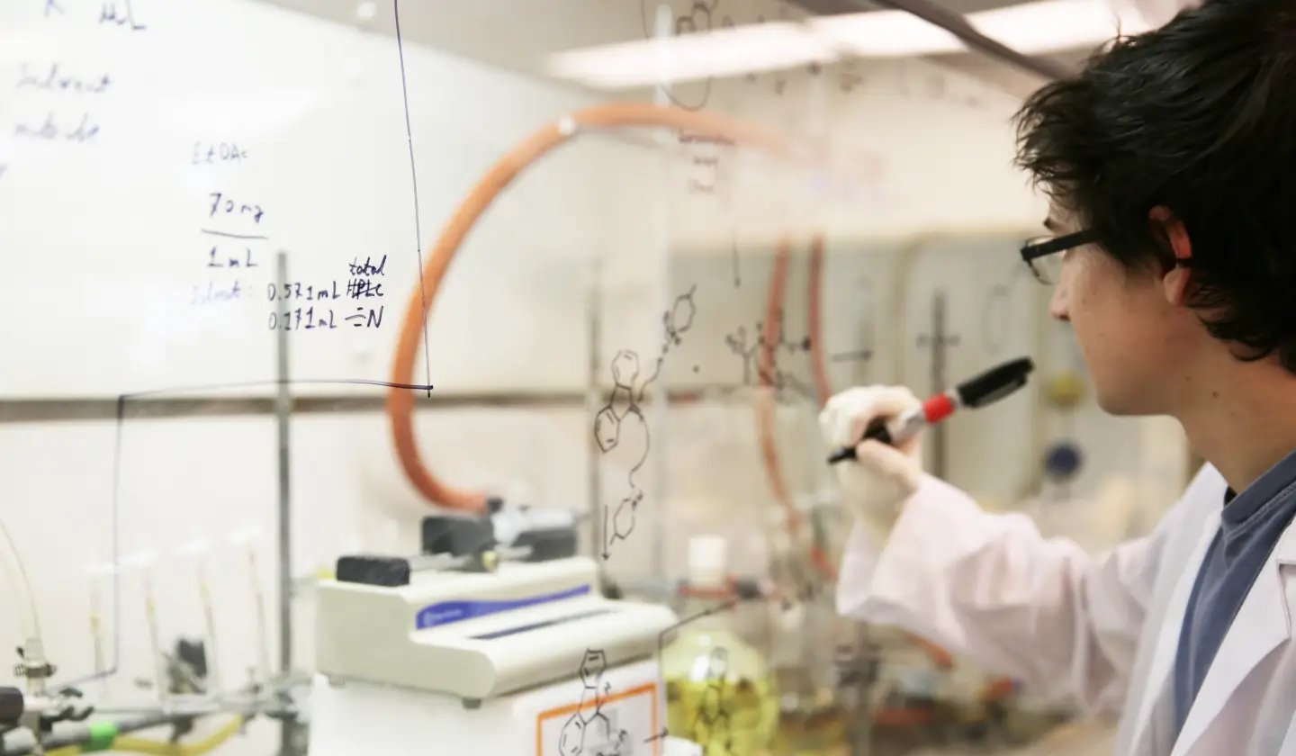 a man writing on a glass wall