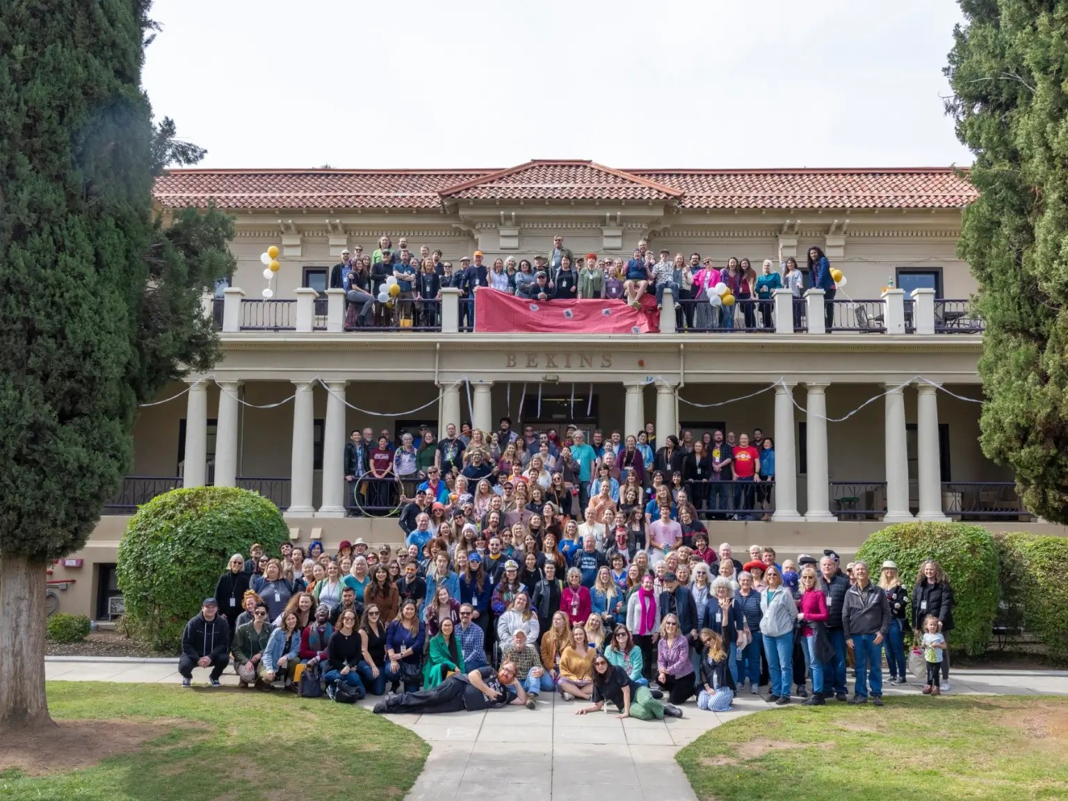 a group of people posing for a photo in front of a building