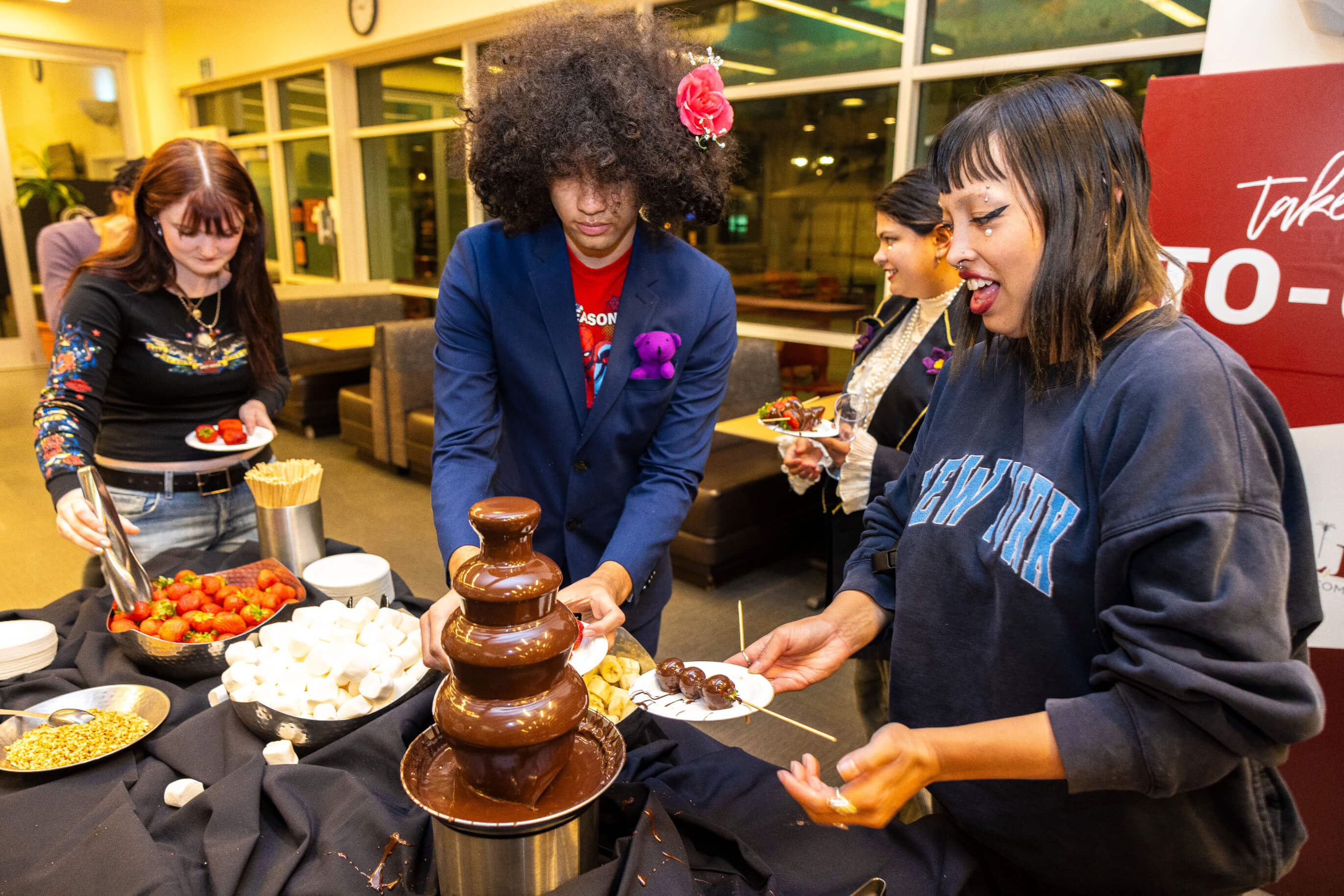 a group of people around a chocolate fountain