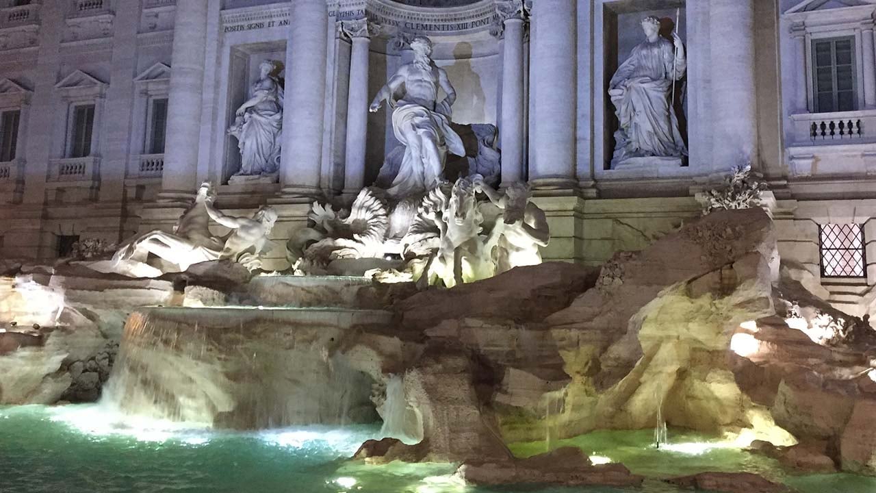 a large fountain with statues and columns with Trevi Fountain in the background