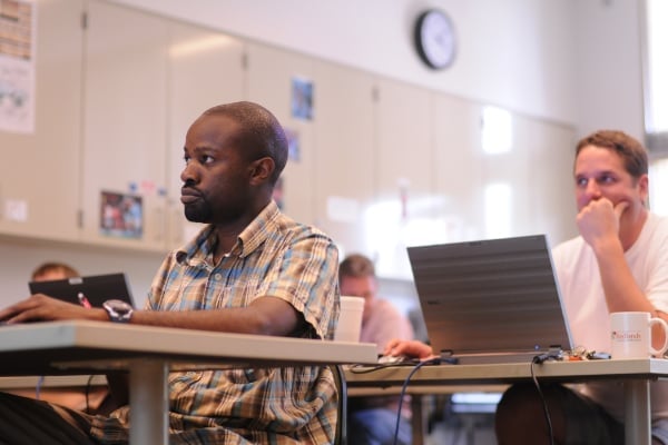 a man sitting at a desk with a laptop