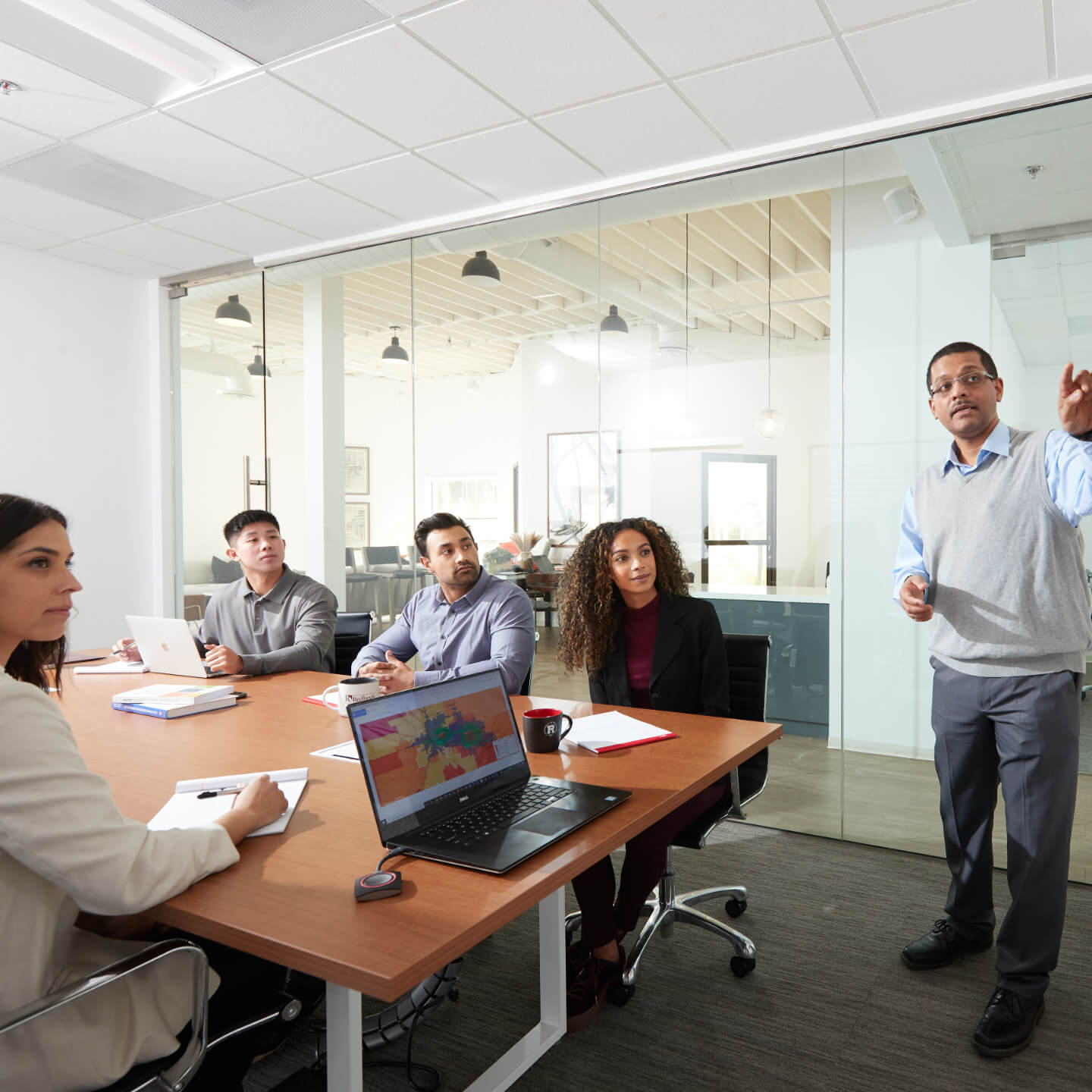 a man standing in front of a group of people around a table