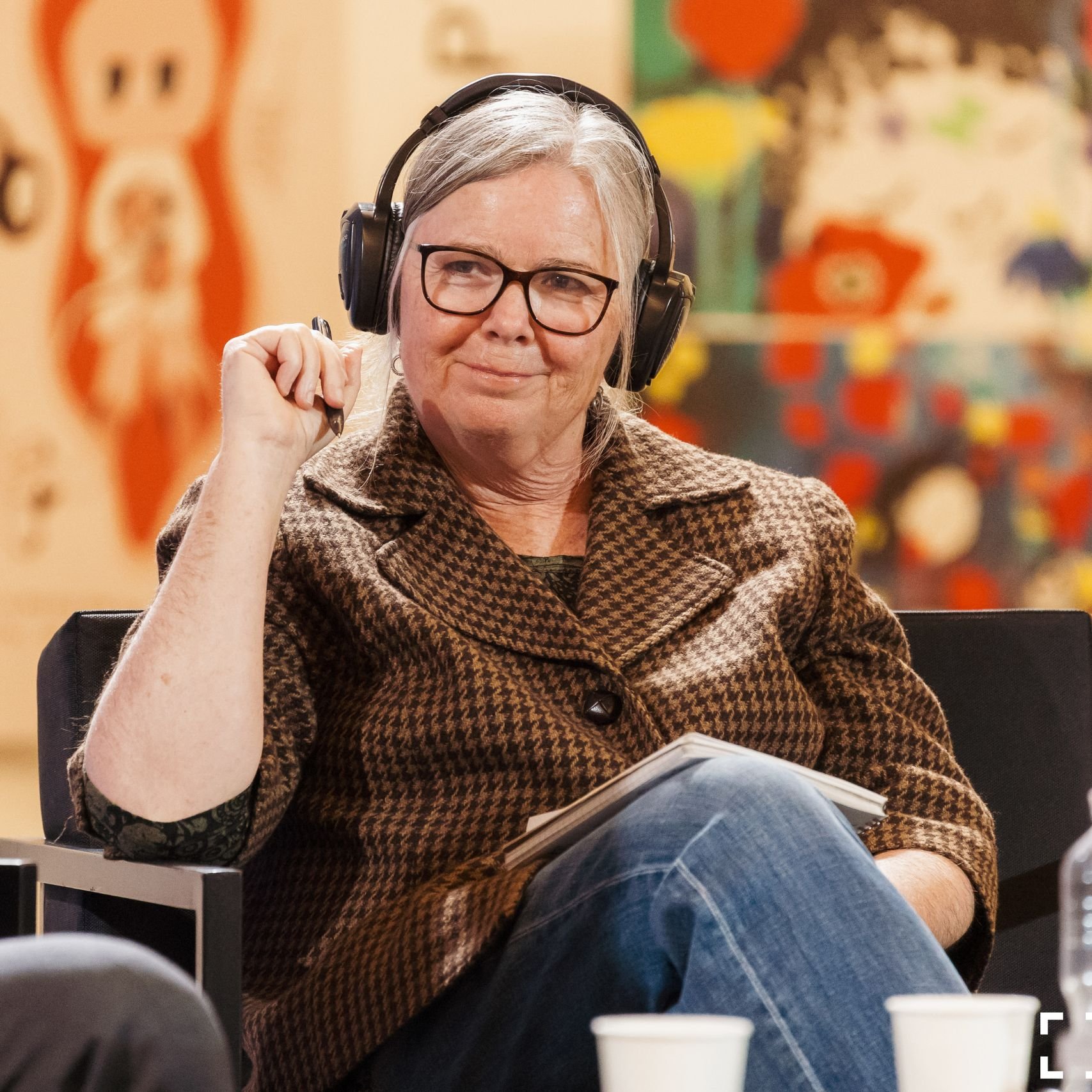 a woman wearing headphones and holding a pen
