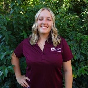 a woman standing in front of a bush