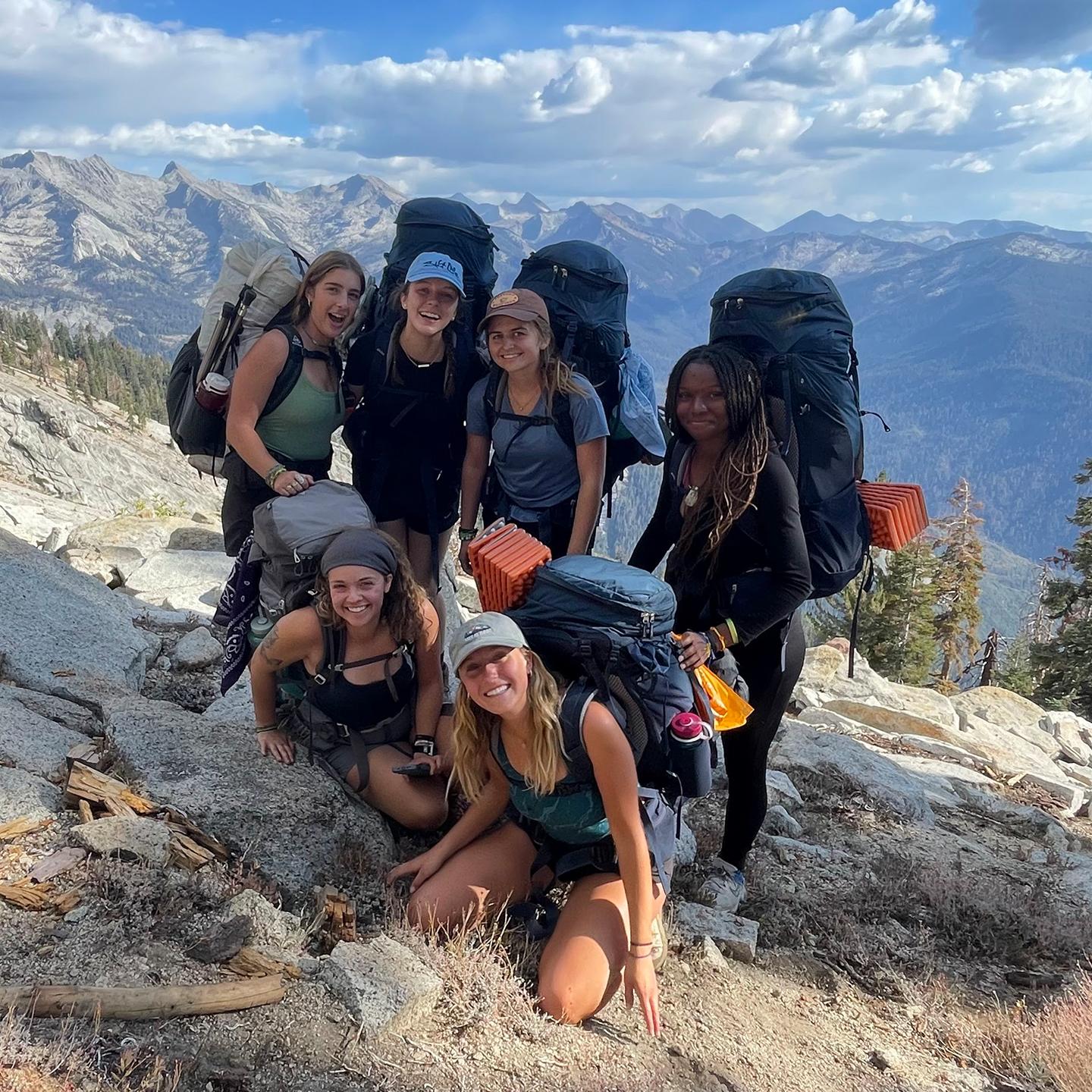 a group of people with backpacks on a mountain