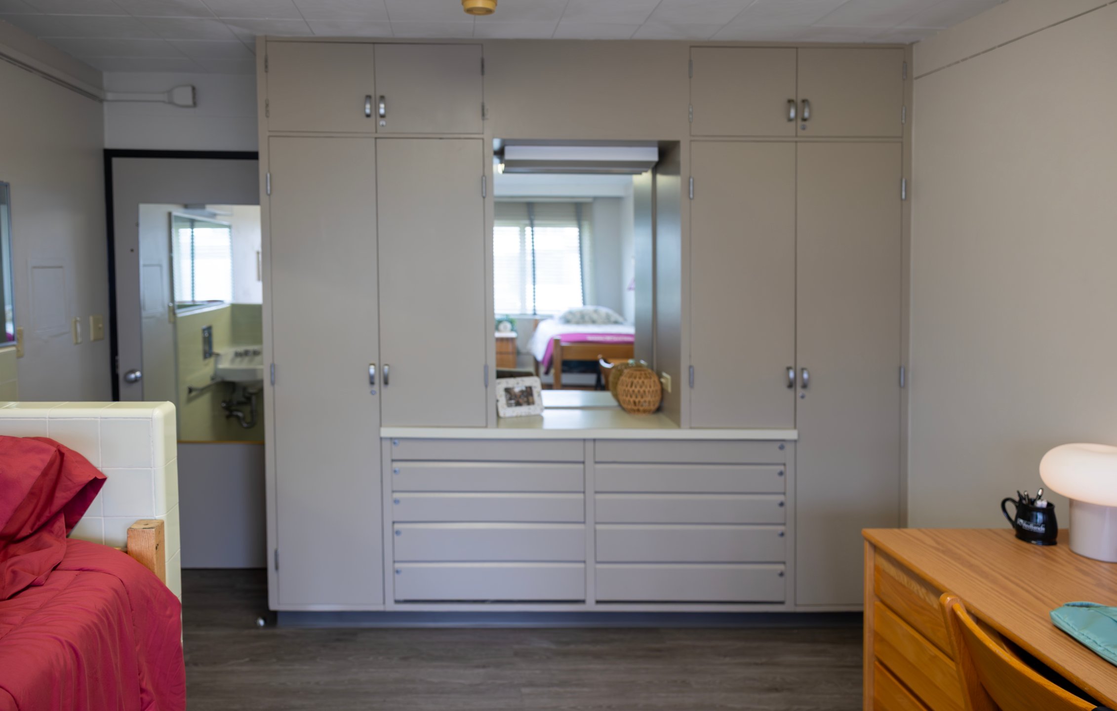 a room with a mirror and cabinets