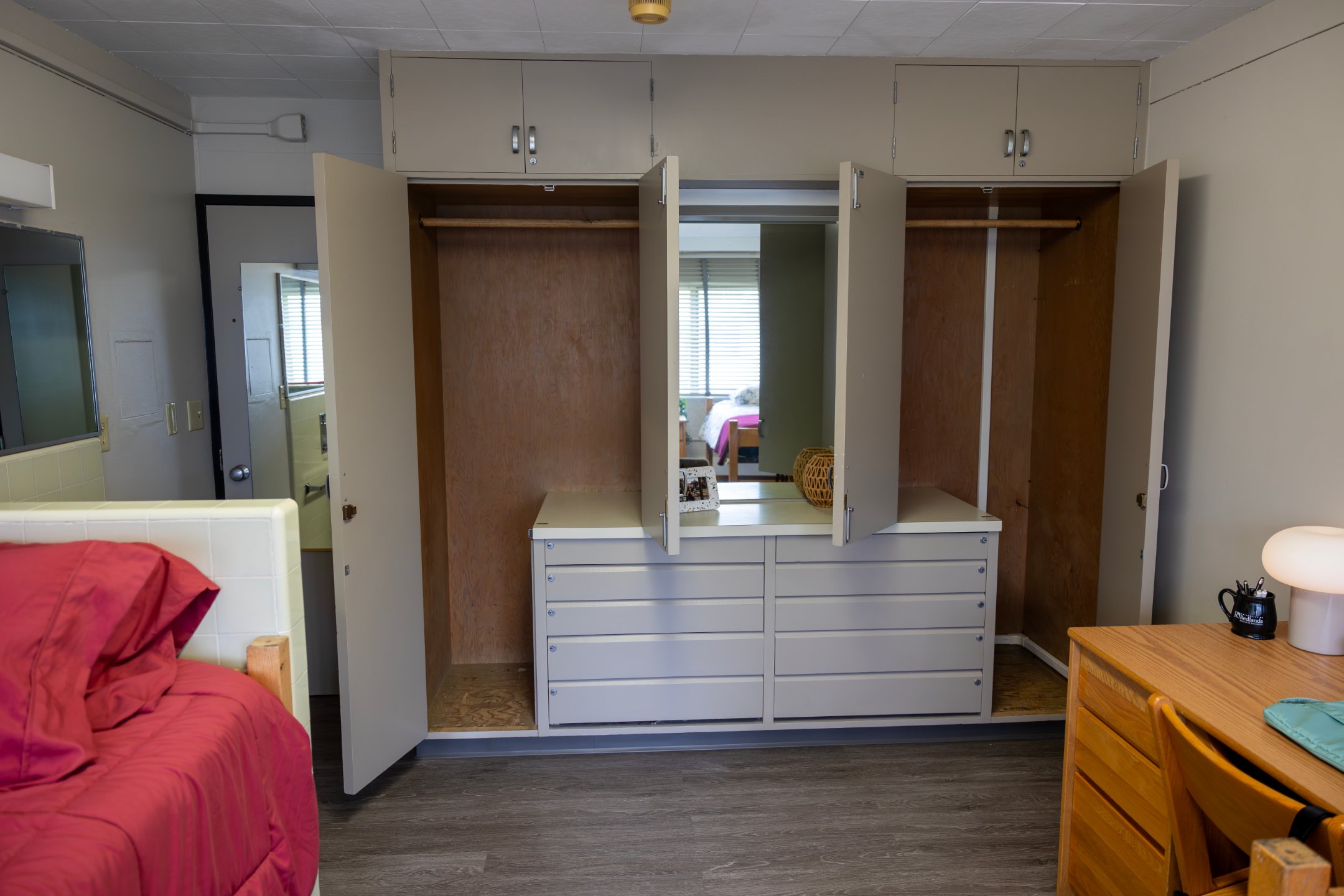 a closet with drawers and mirror