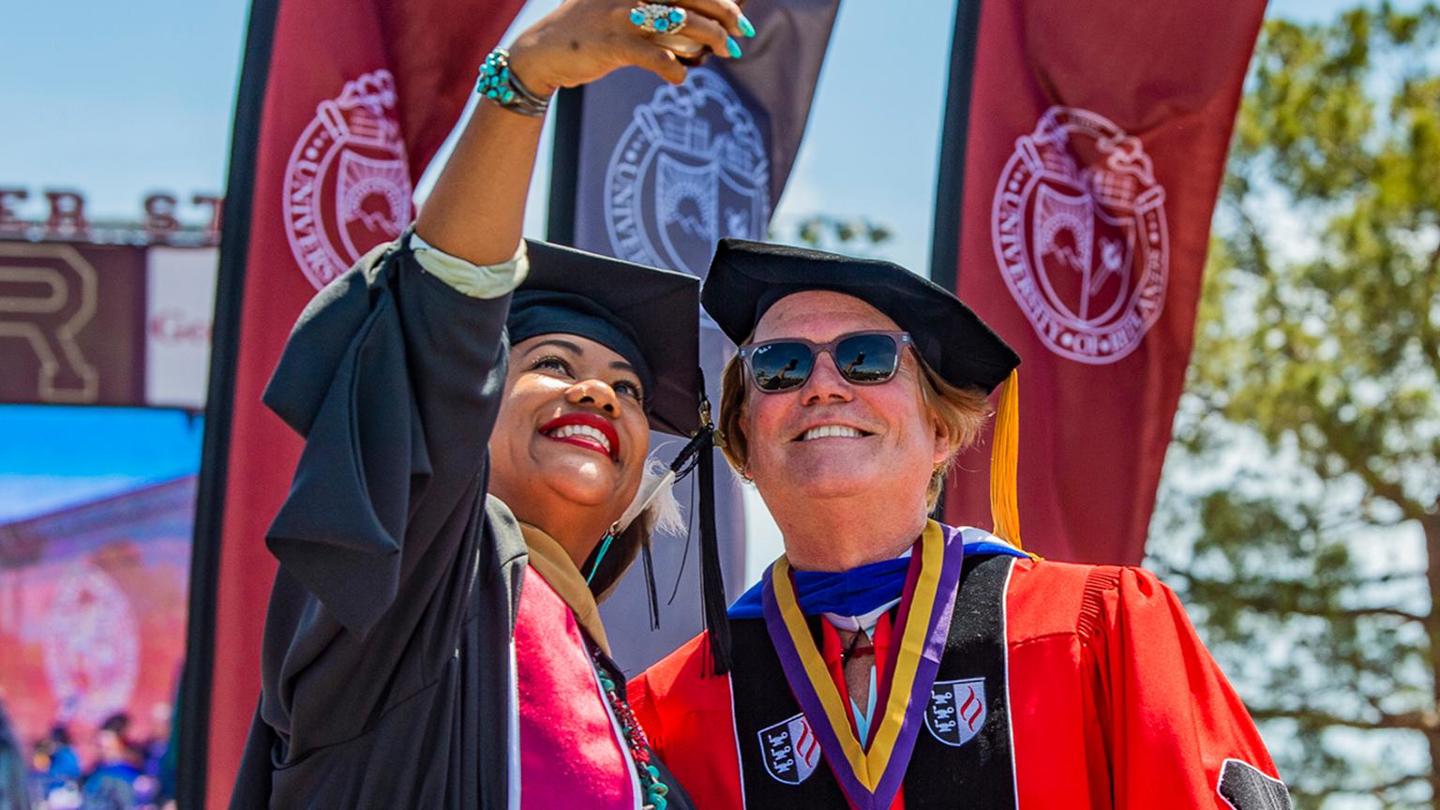 Image card - SBS graduate capturing selfie with Dean