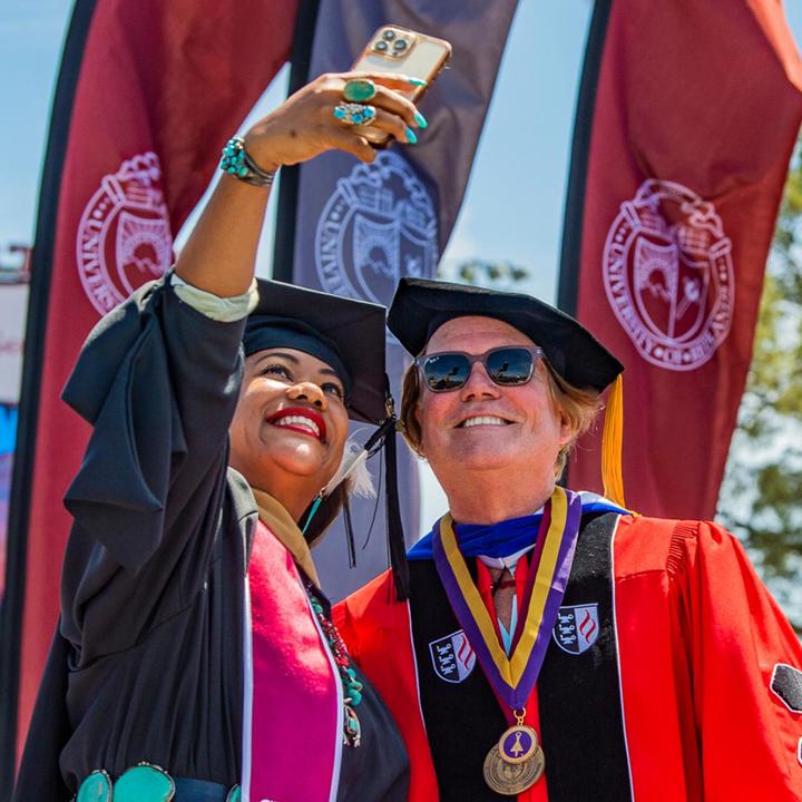 Image card - SBS graduate capturing selfie with Dean