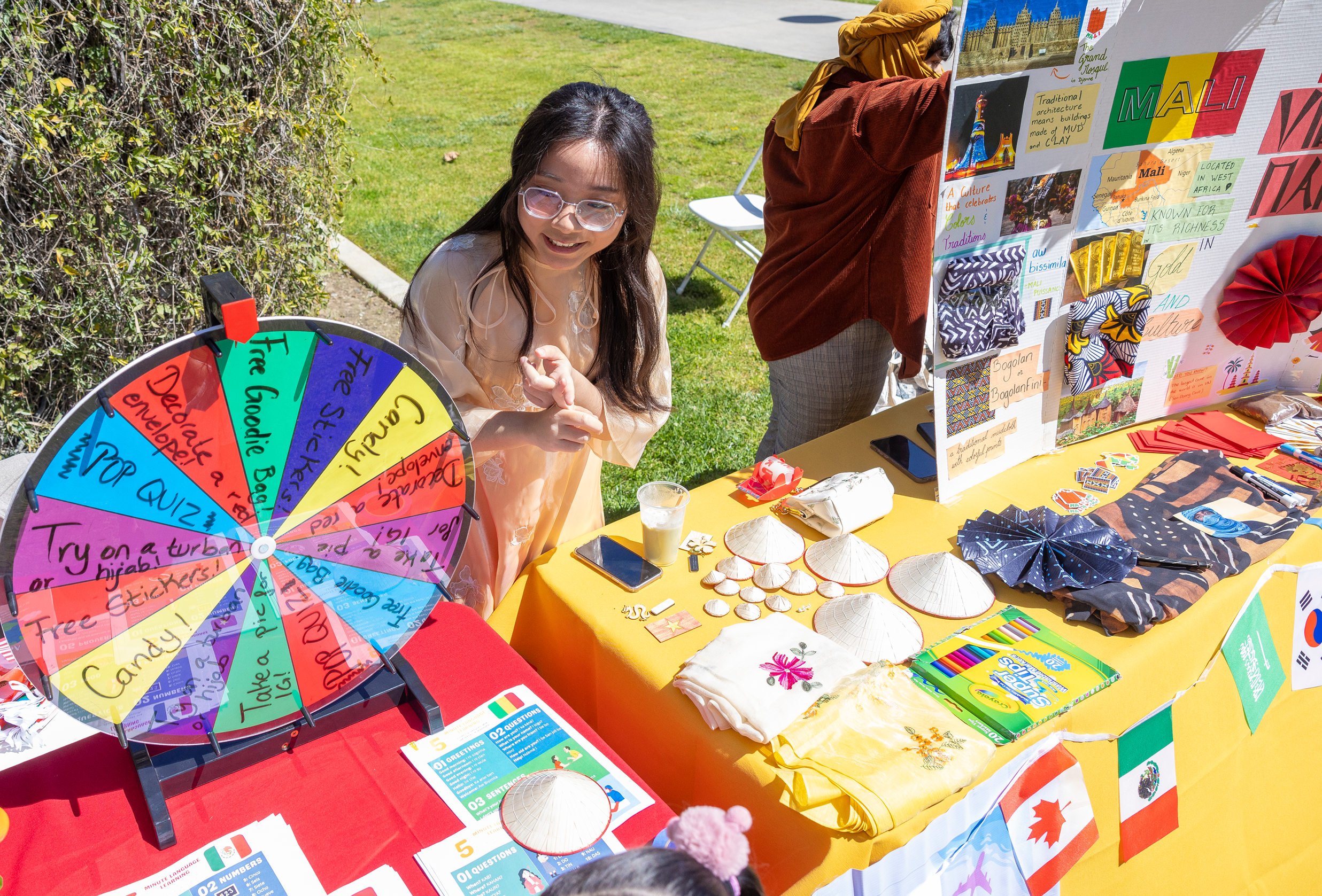 a woman standing in front of a table with a wheel of paper and other items