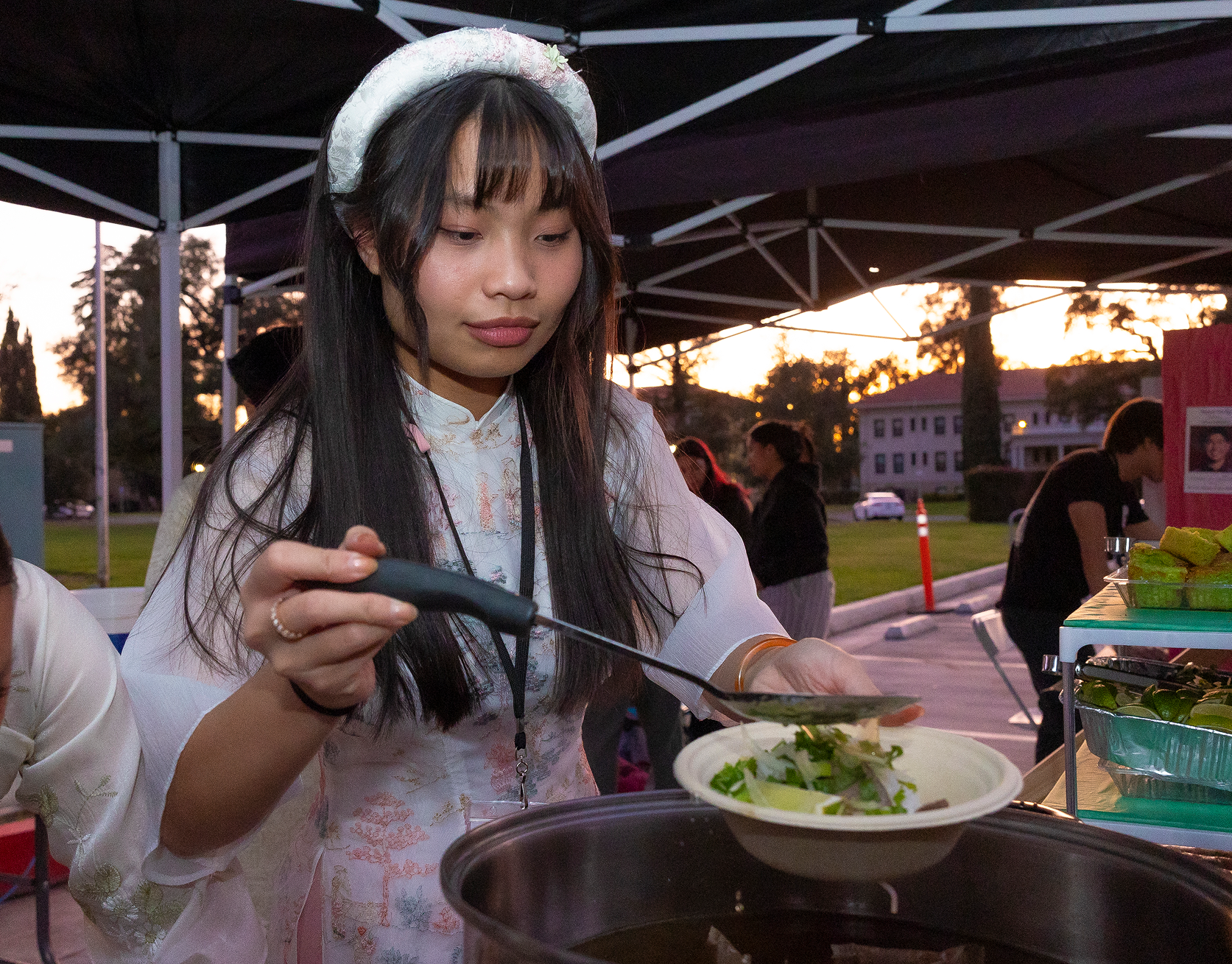 a woman holding a ladle over a bowl of soup