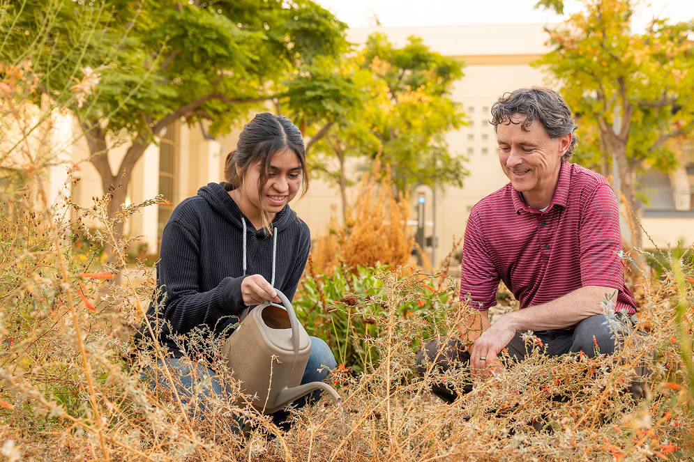 a man and woman watering plants