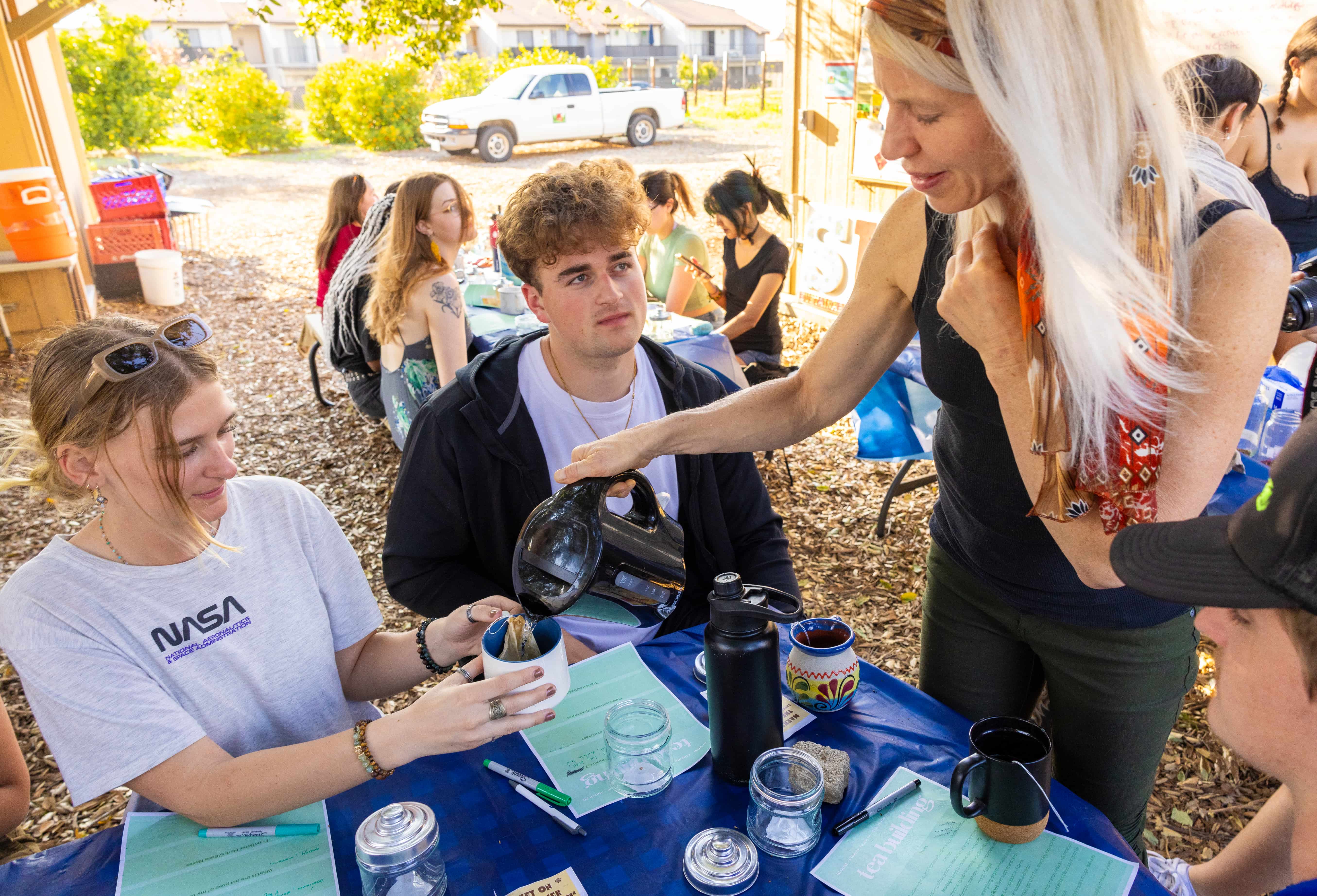 a woman pouring tea into a cup