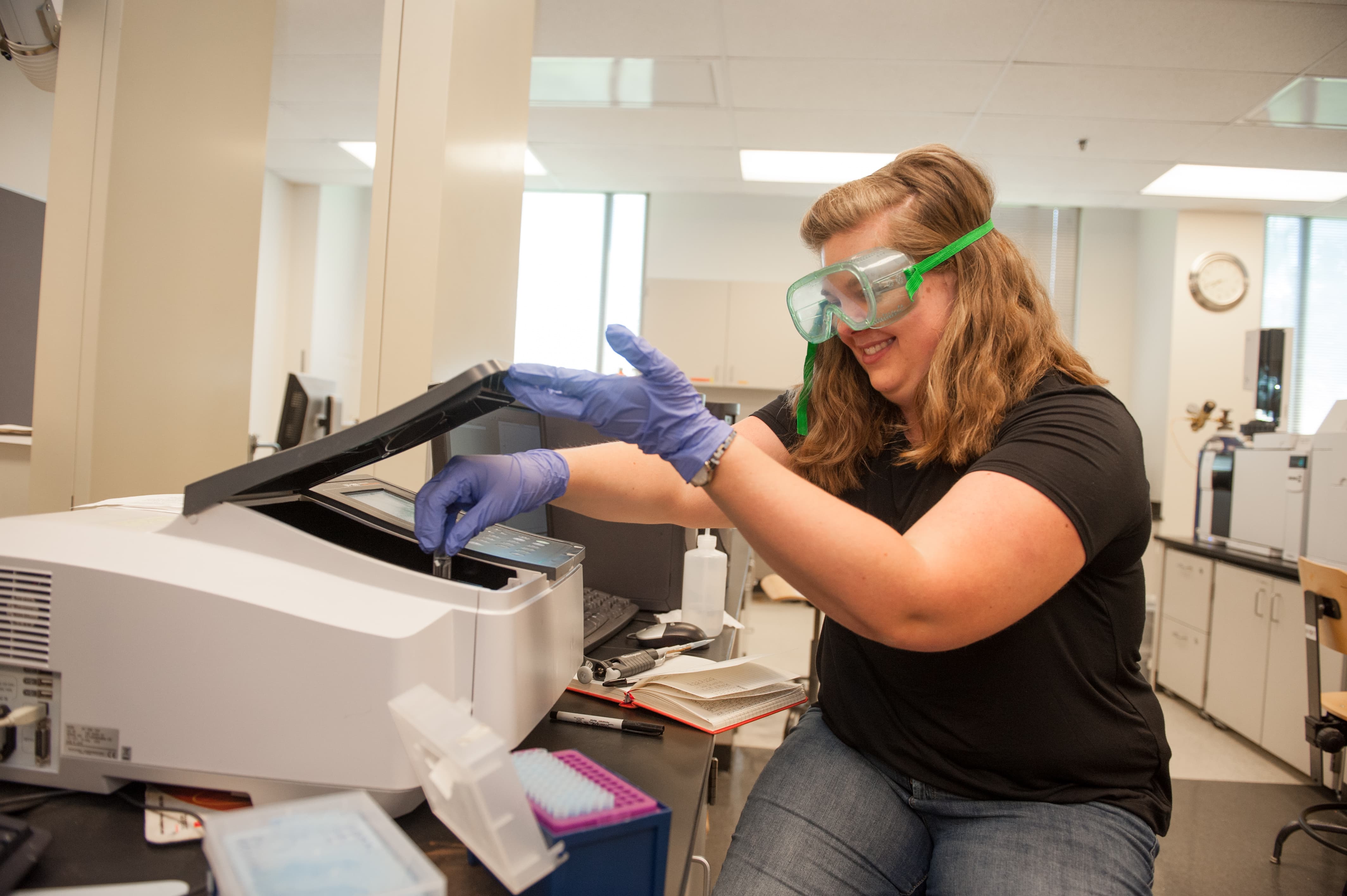 a woman wearing safety goggles and gloves