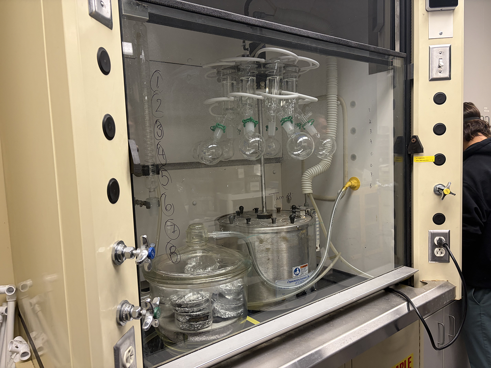 a glass container with round glass containers and a pipe in a cabinet
